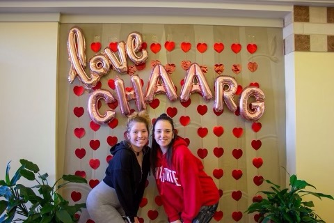 Christina in front of a sign reading "love CHAARG"