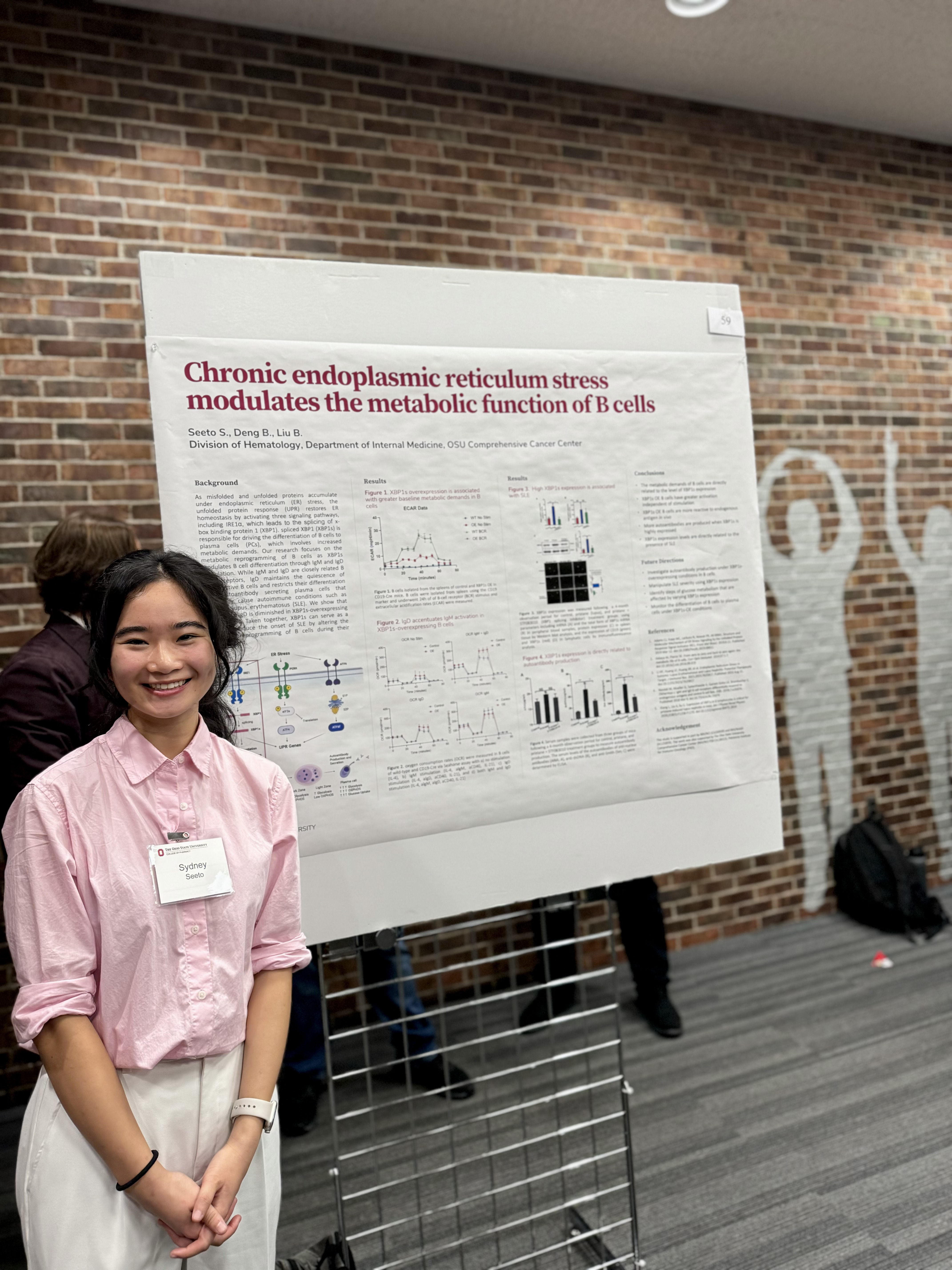 Sydney Seeto standing by a poster