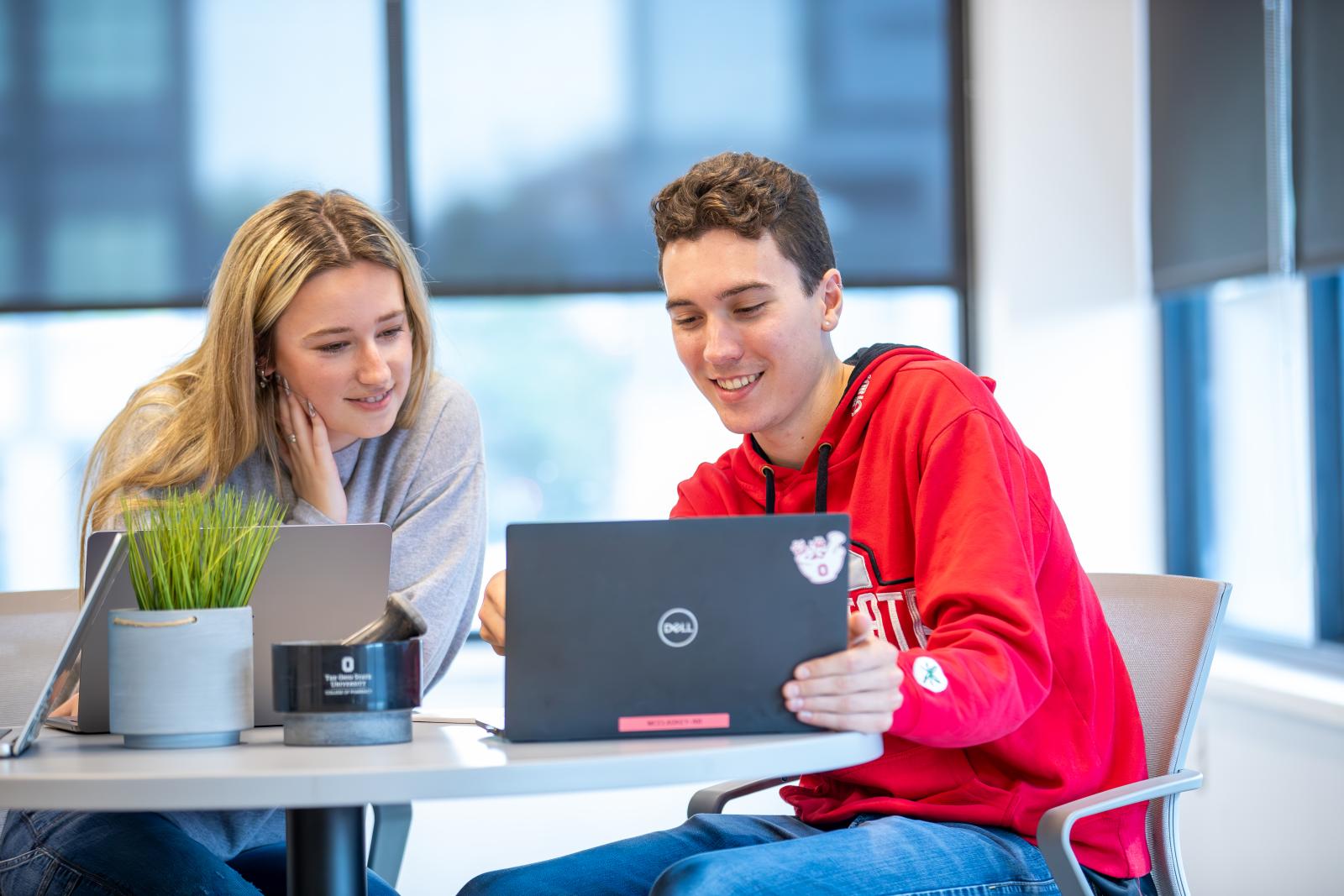 Two students gathered around a laptop
