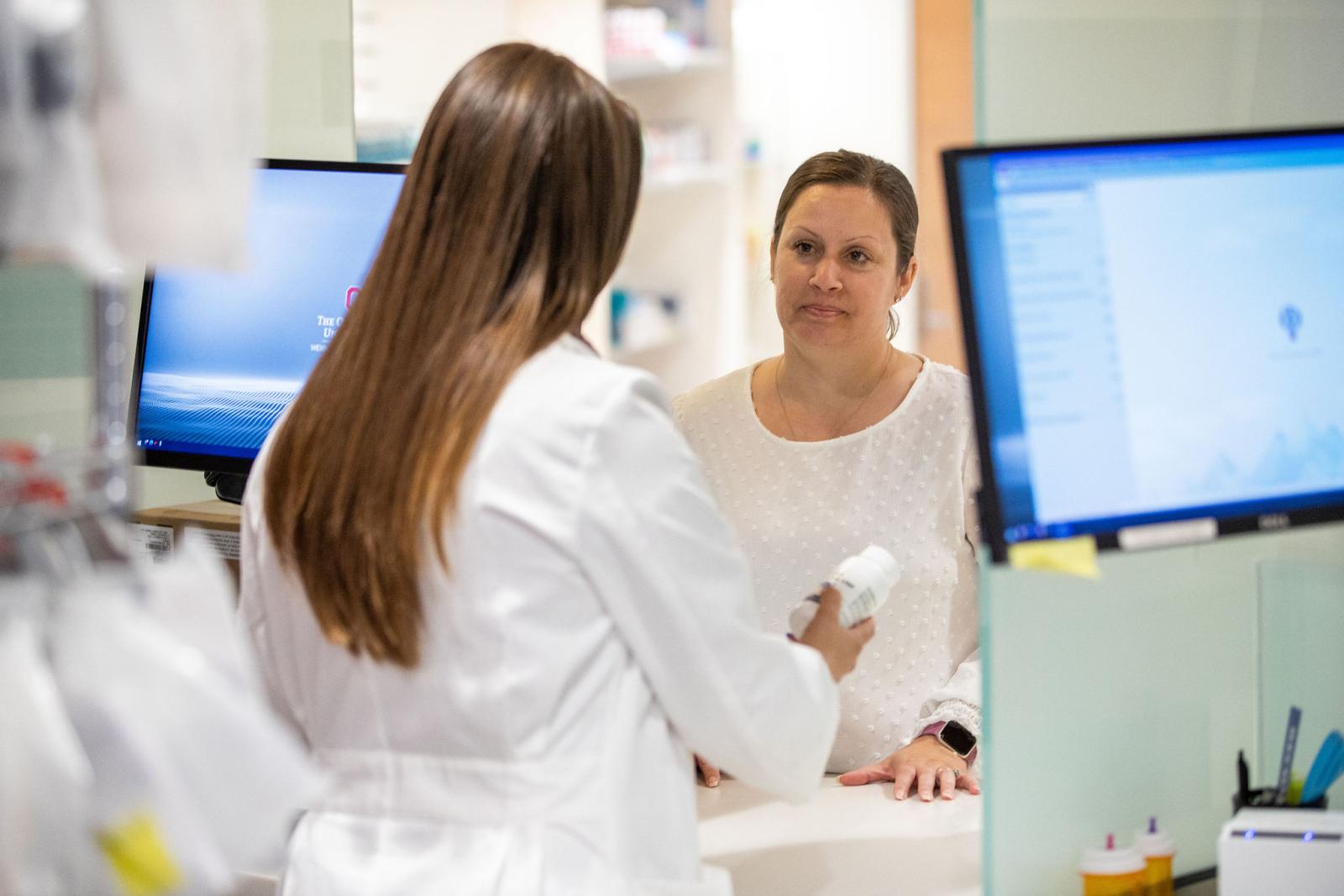 Pharmacist providing patient counseling at a community pharmacy counter