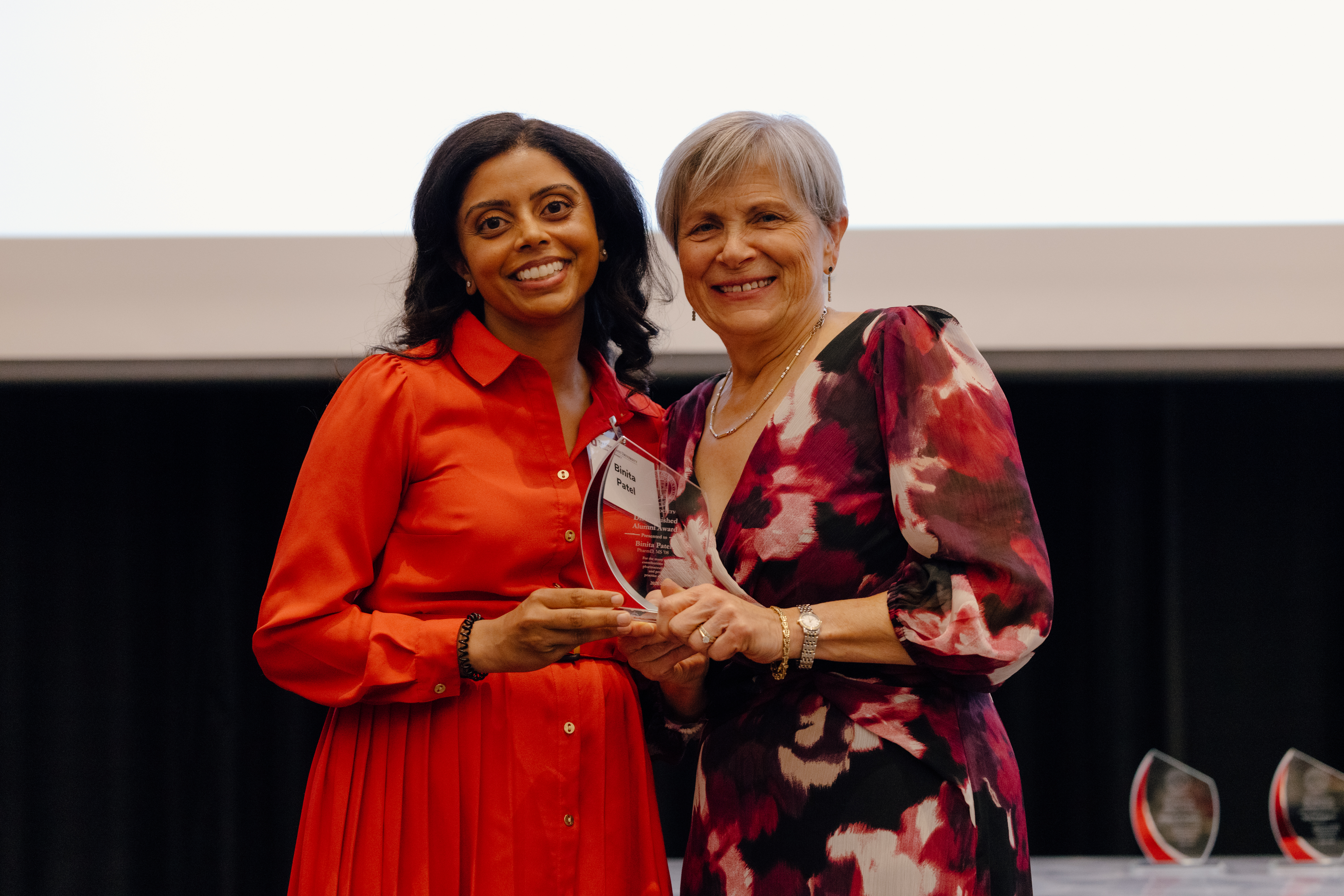 Dr. Patel and Dean Deanna Kroetz presenting the Distinguished Alumni Award