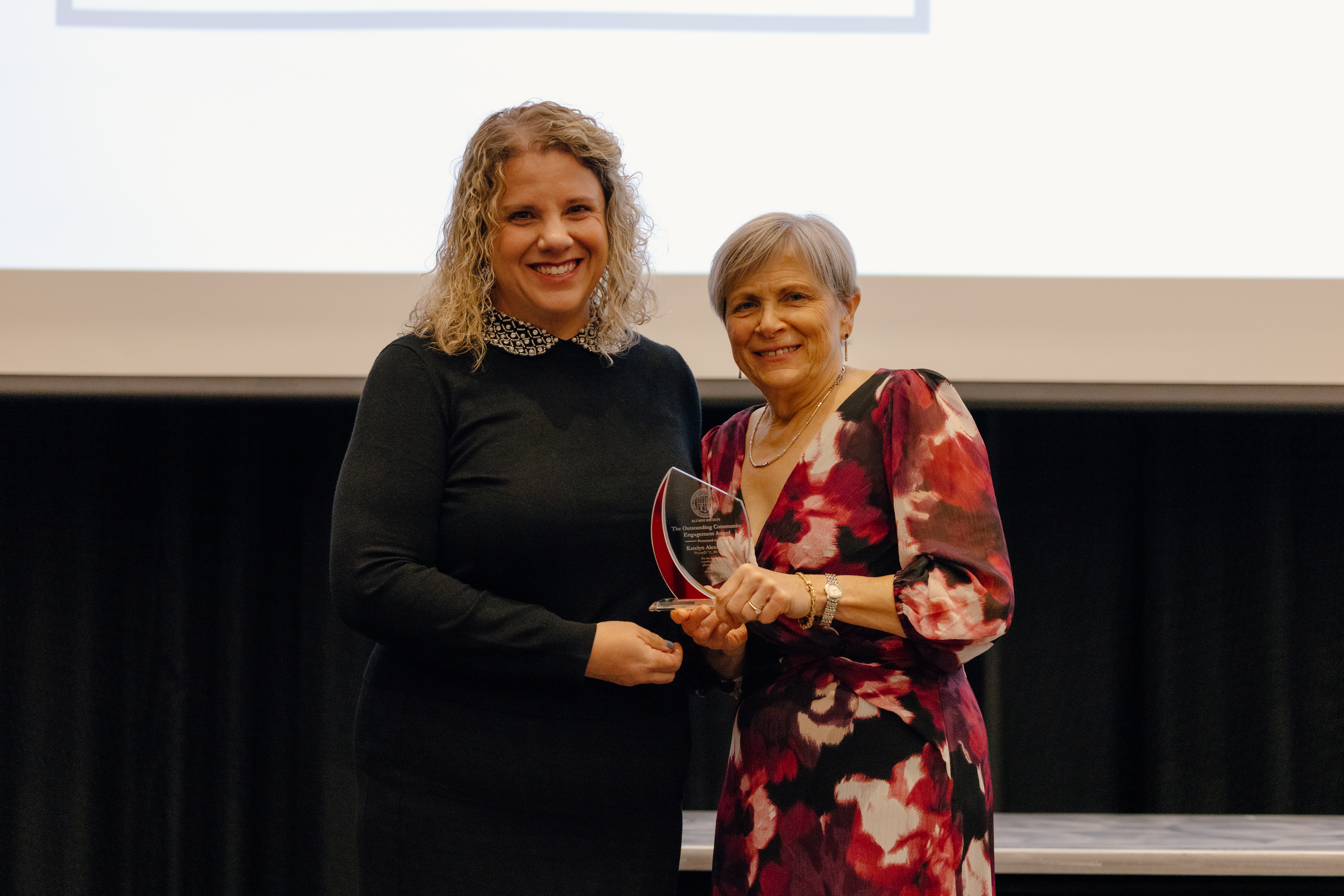 Dr. Alexander and Dean Deanna Kroetz presenting the Outstanding Community Engagement Award