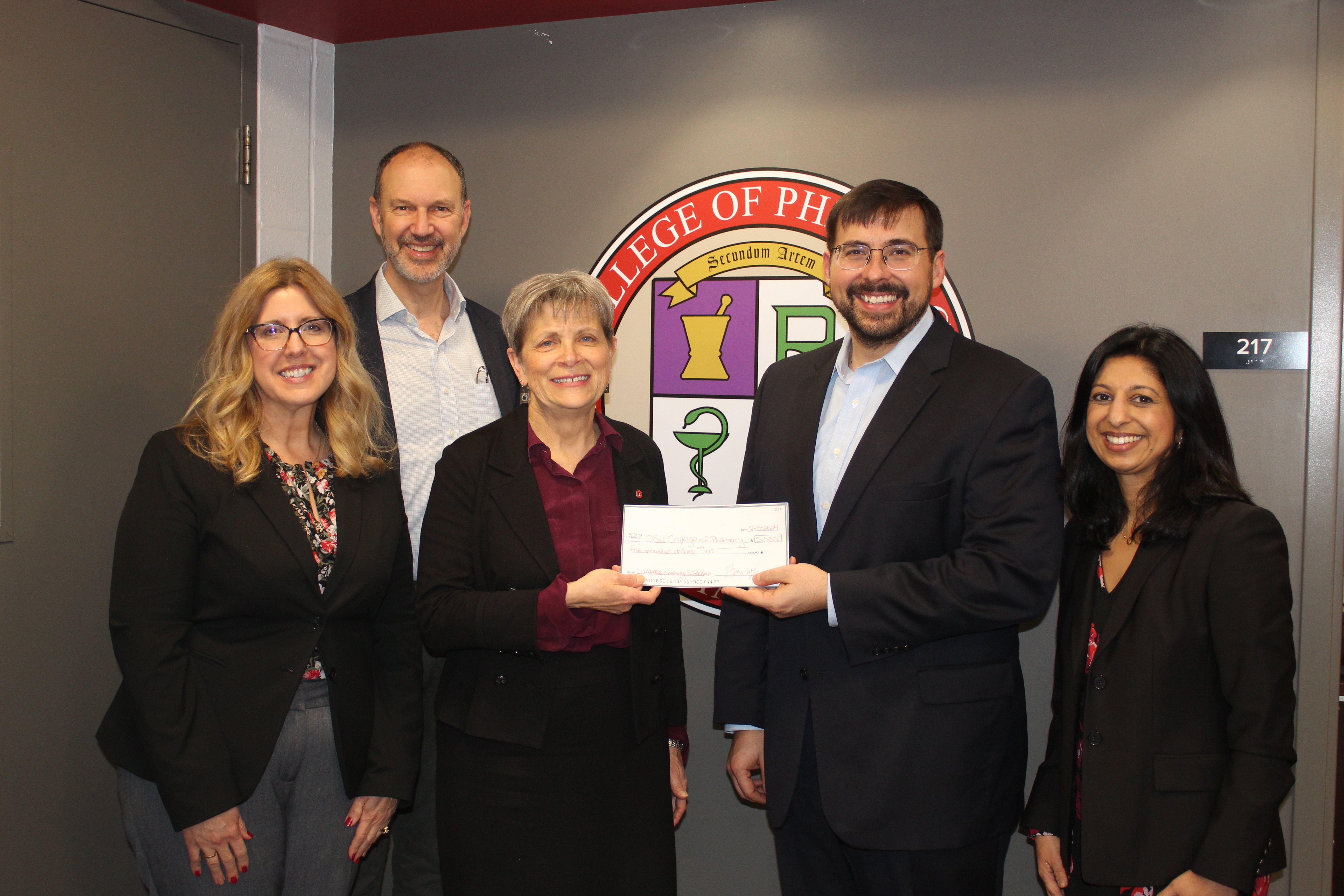 dr ryan wagner presenting a check to college personnel