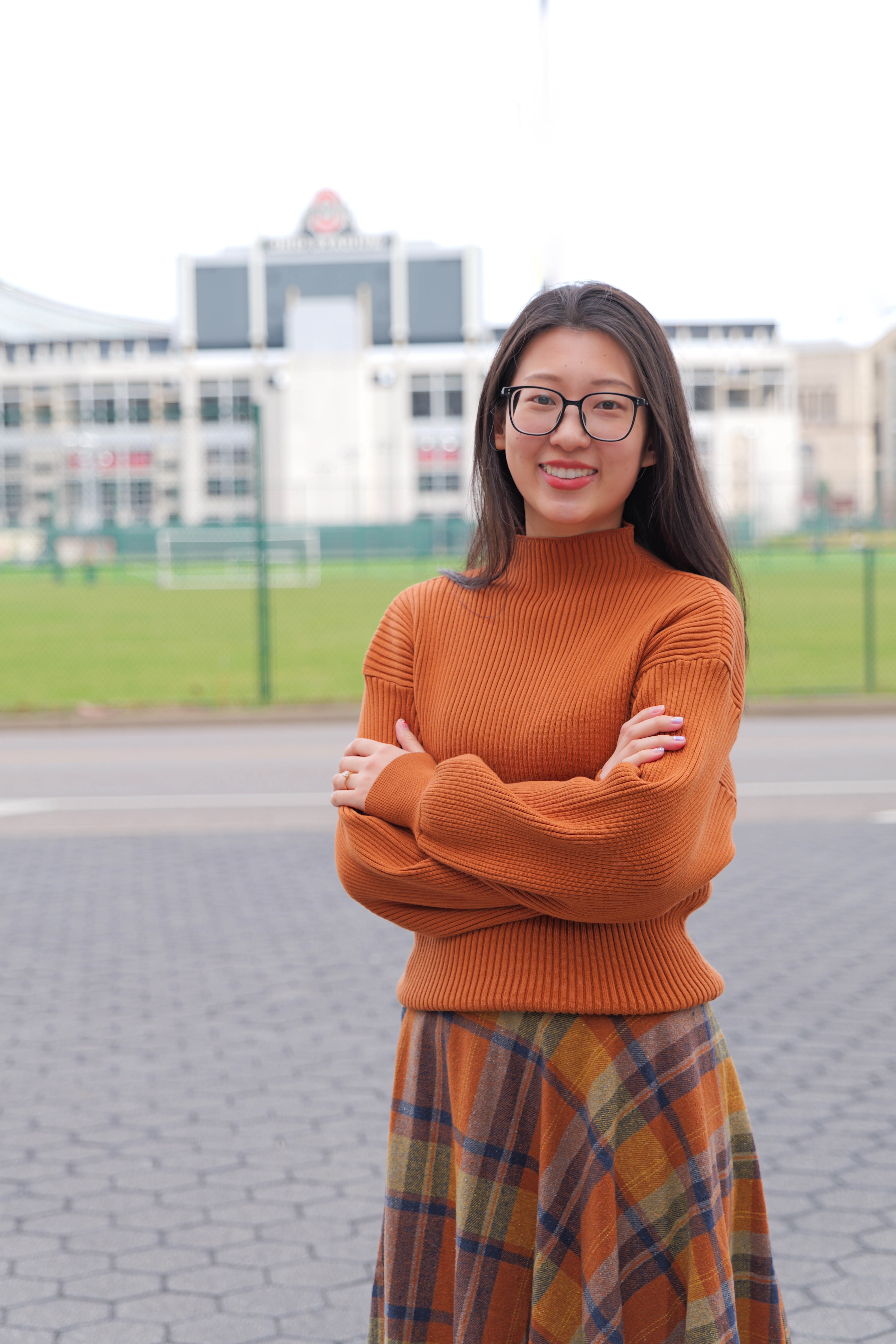PhD candidate Min Hai standing in front of Ohio Stadium