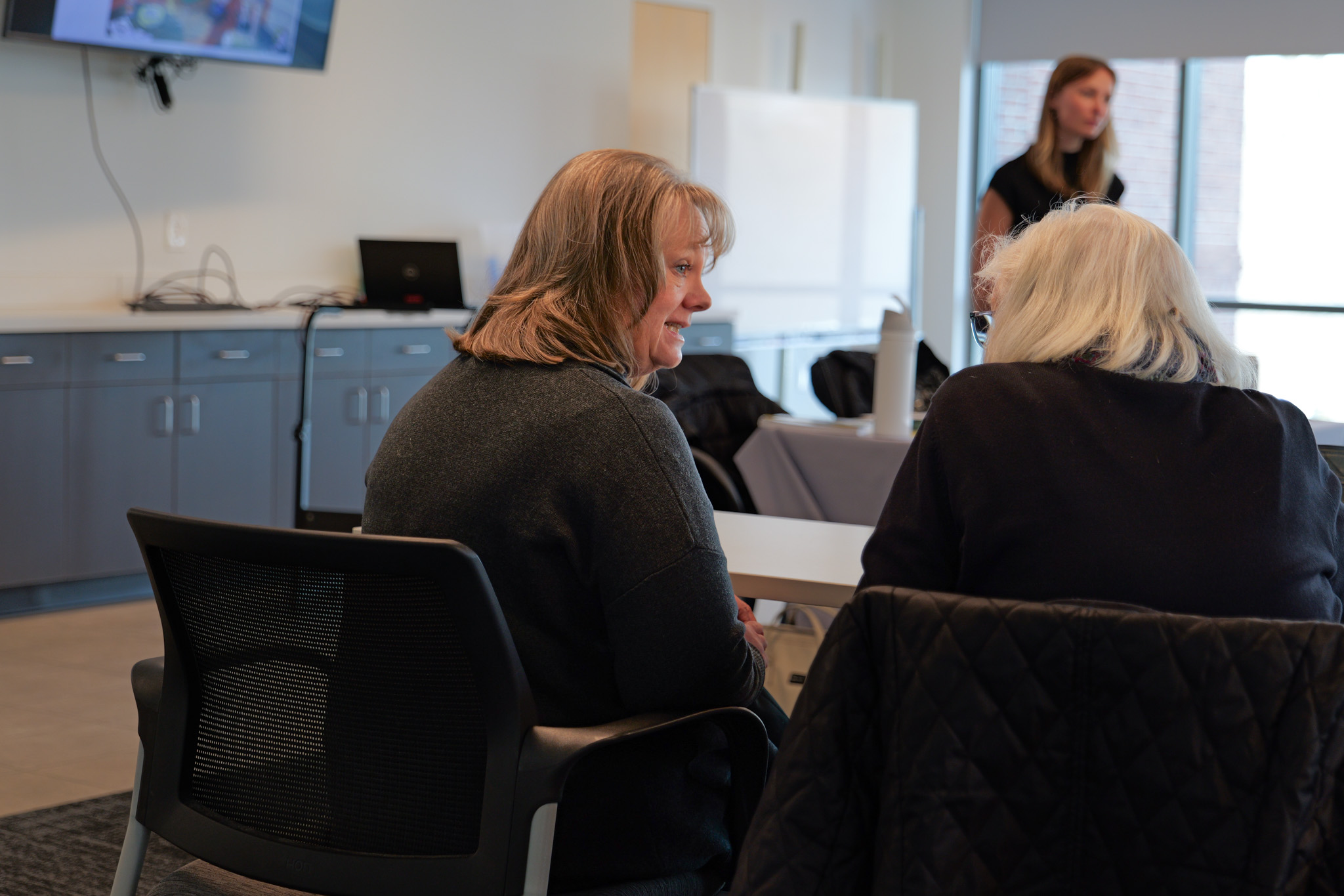 Dr. Emptage speaking with an older adult at an education session
