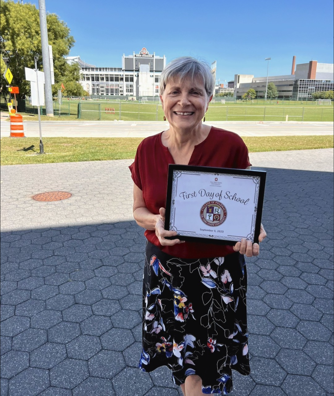 Dean Kroetz posing with a "First Day of School" plaque