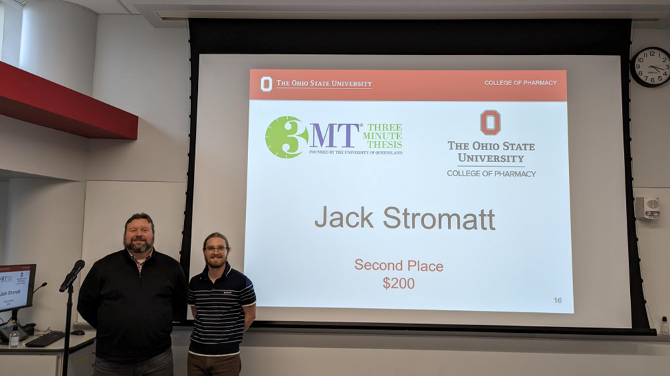 jack stromatt and jim fuchs posing in front of projector screen