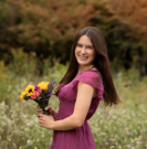 a person holding flowers in a field