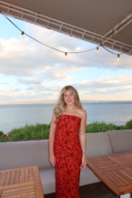 a person posing on a terrace with ocean in background