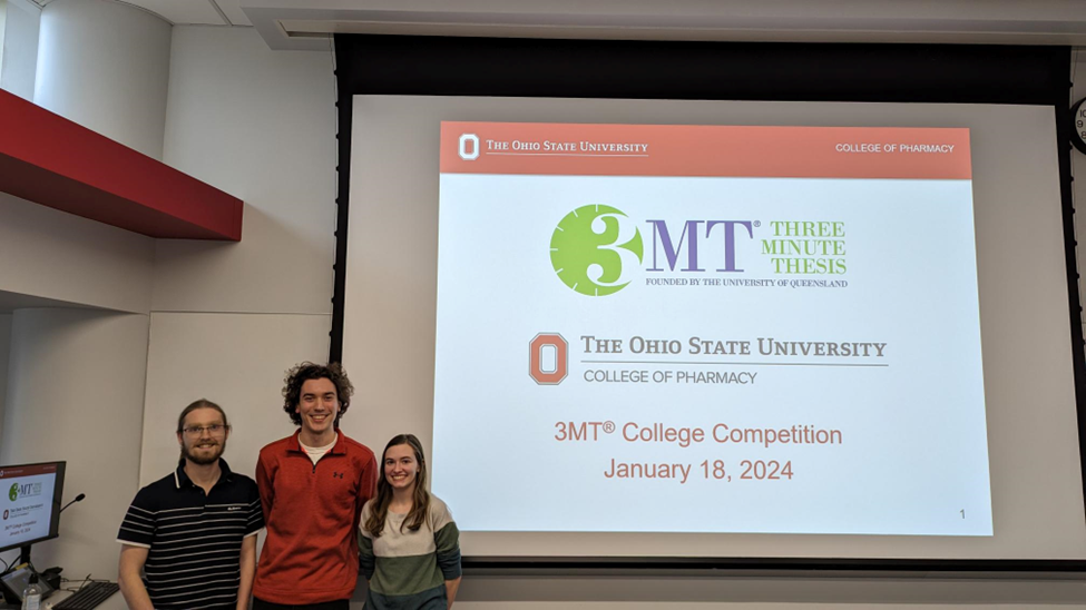 all three winners posing in front of projector screen