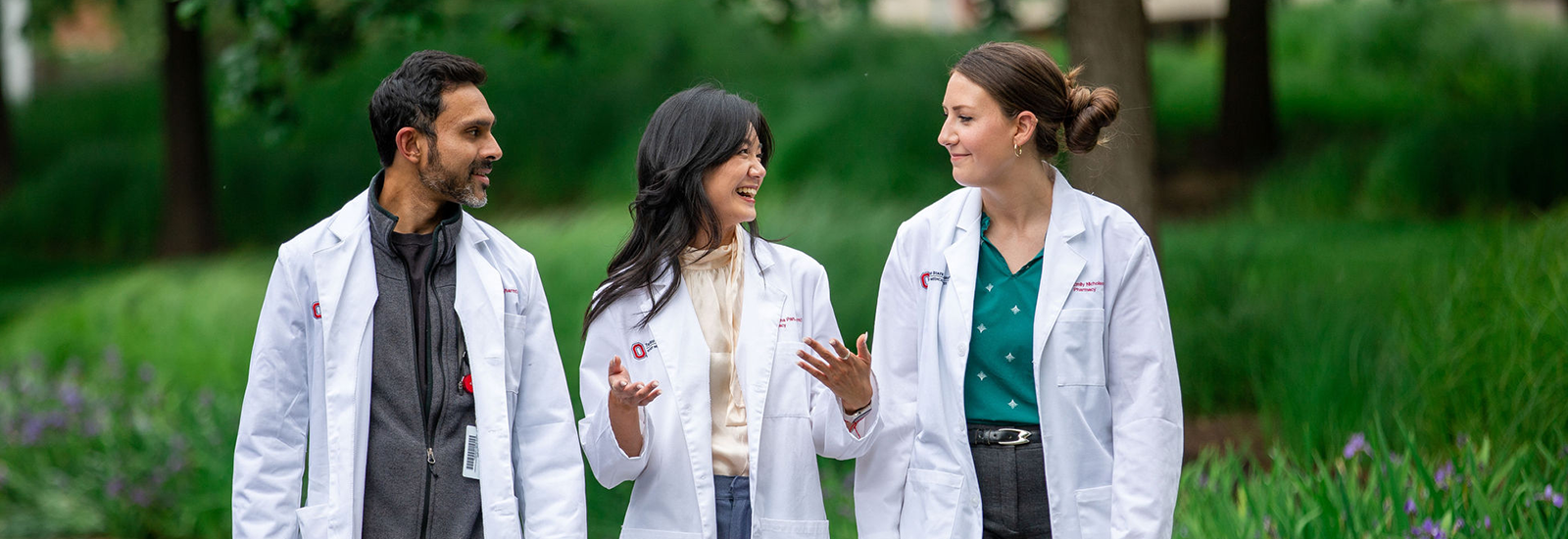 Students in white coats outside conversing