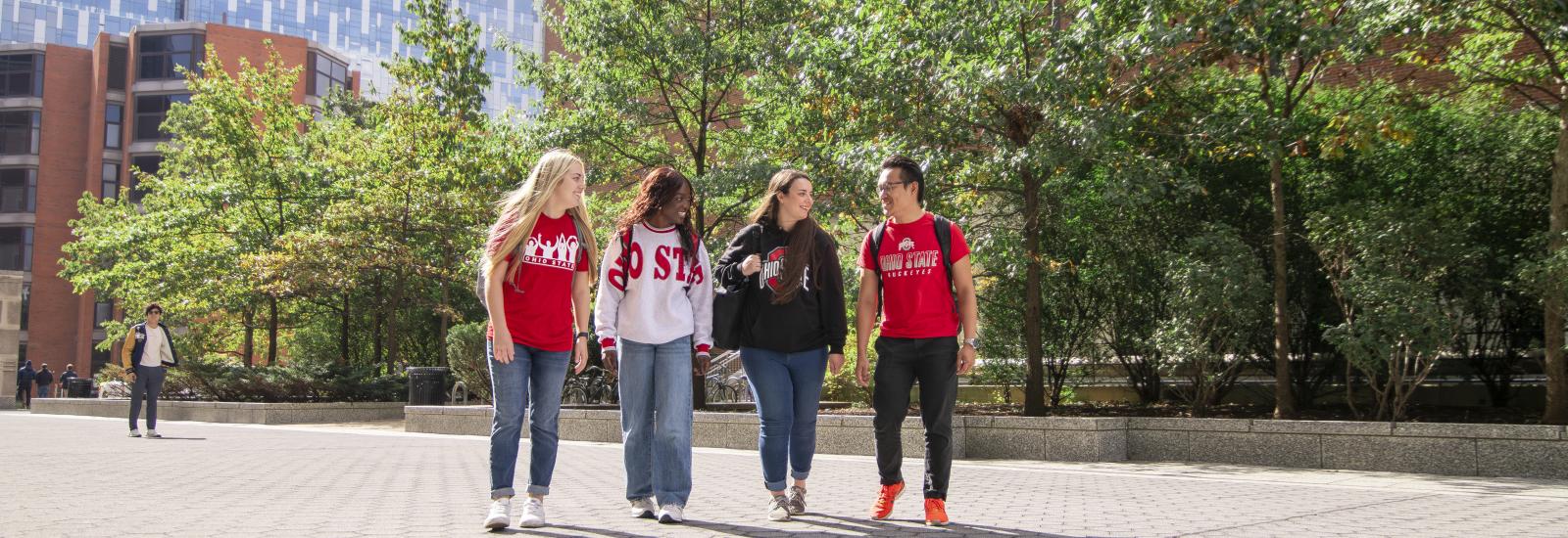 four students walking with the james in the background