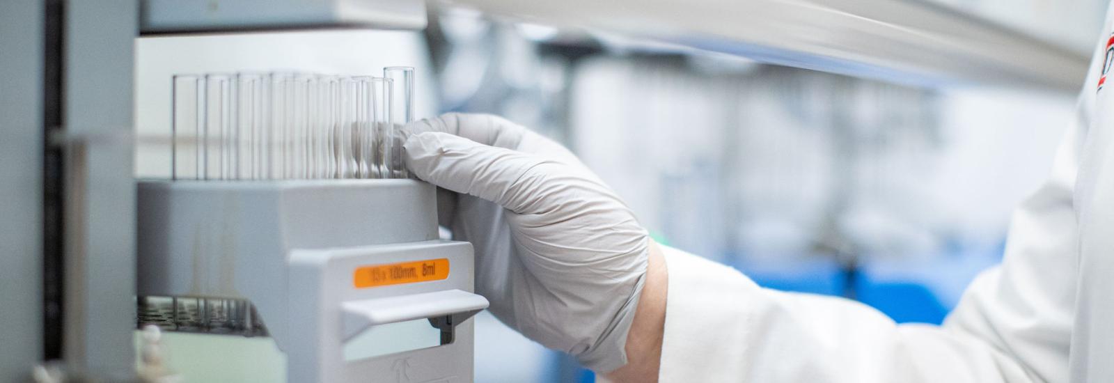 gloved hand of a researcher grabbing a device