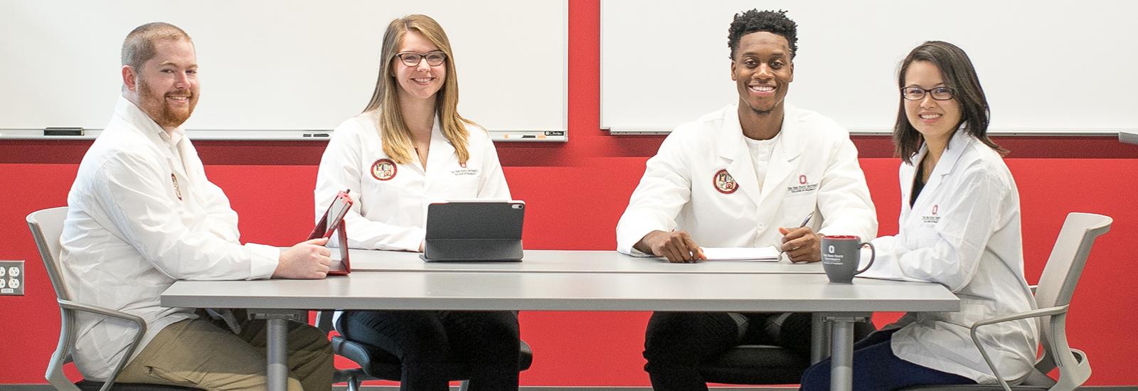 students in white coats looking at camera