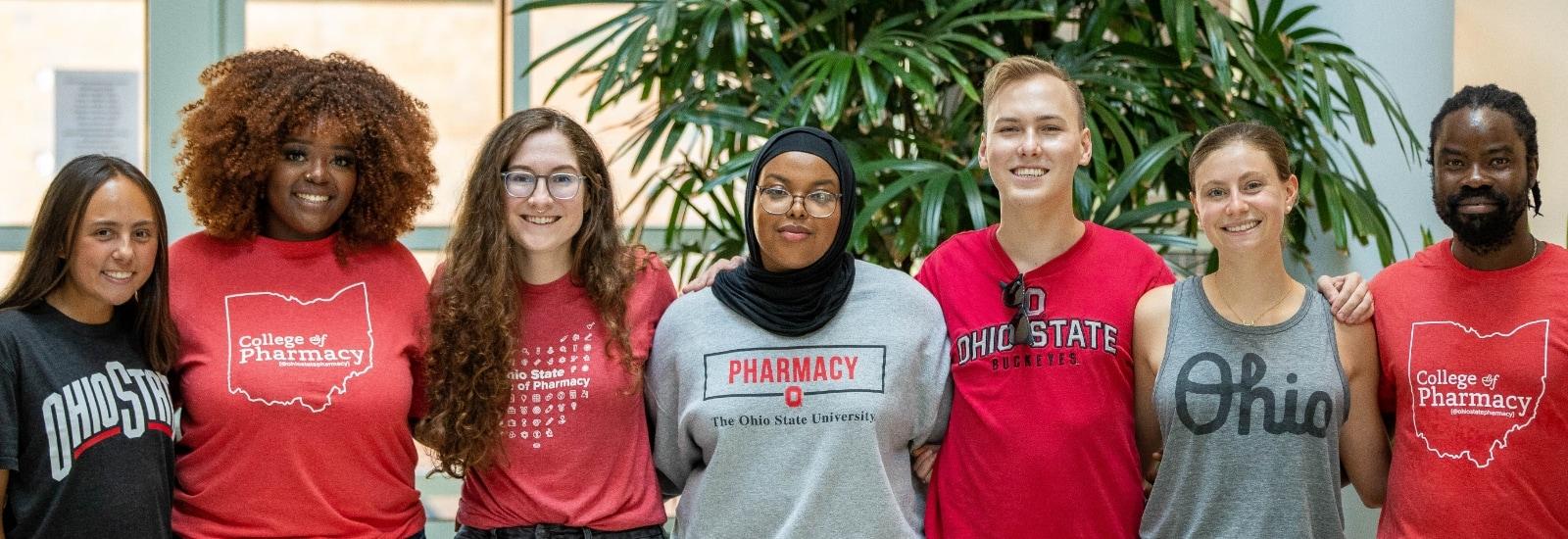 students standing in a line in pharmacy shirts