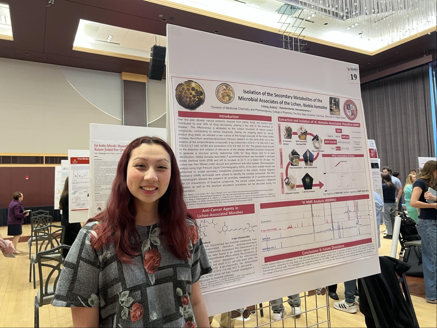 Aubrey Liming in front of her poster smiling.
