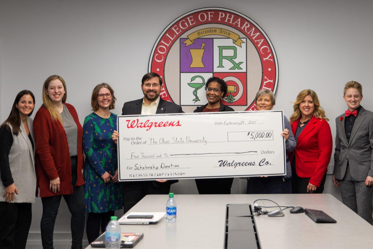 a group of people holding a large check