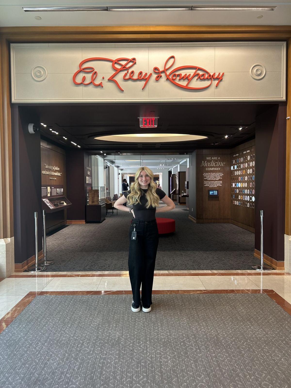 Mari Lynn standing below "Eli Lilly & Company" sign