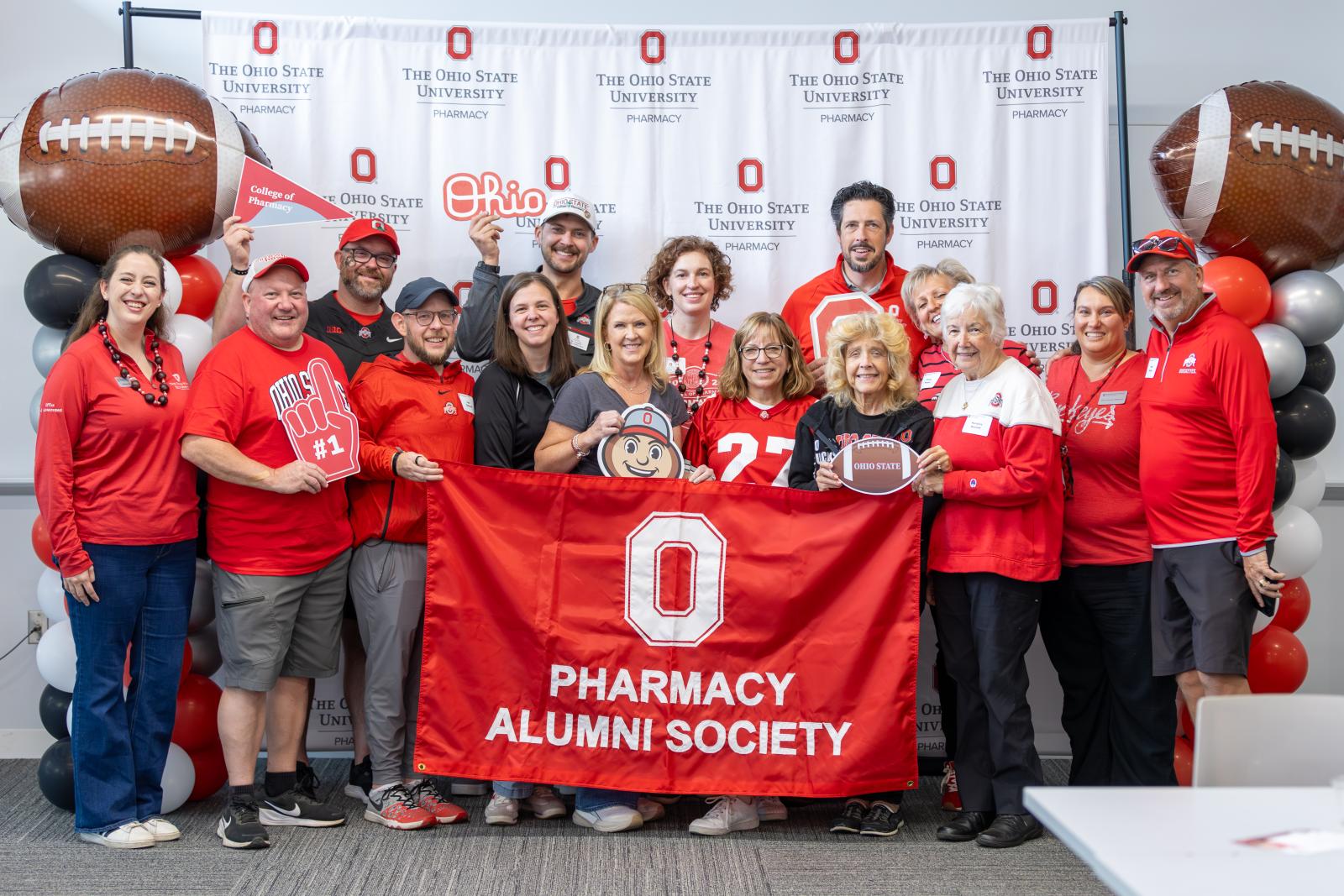 A group of people holding a College of Pharmacy Alumni banner