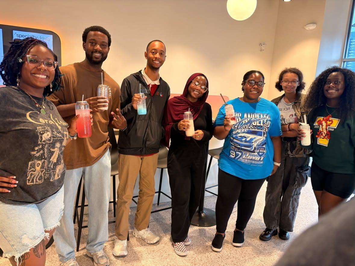 Seven people holding drinks and smiling