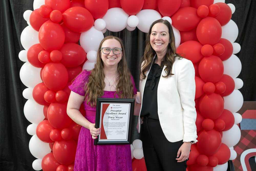 Dr. Wiczer holding award and woman standing beside her