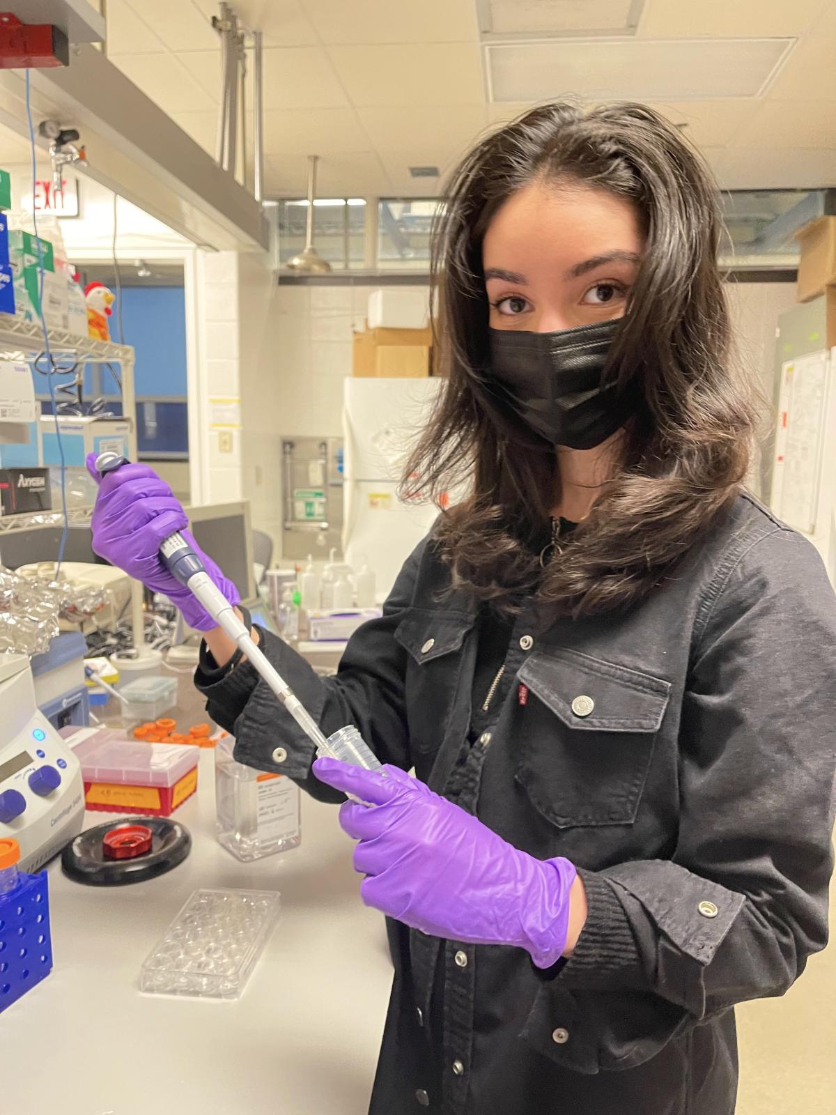 Amani Djouadi conducting research in a lab