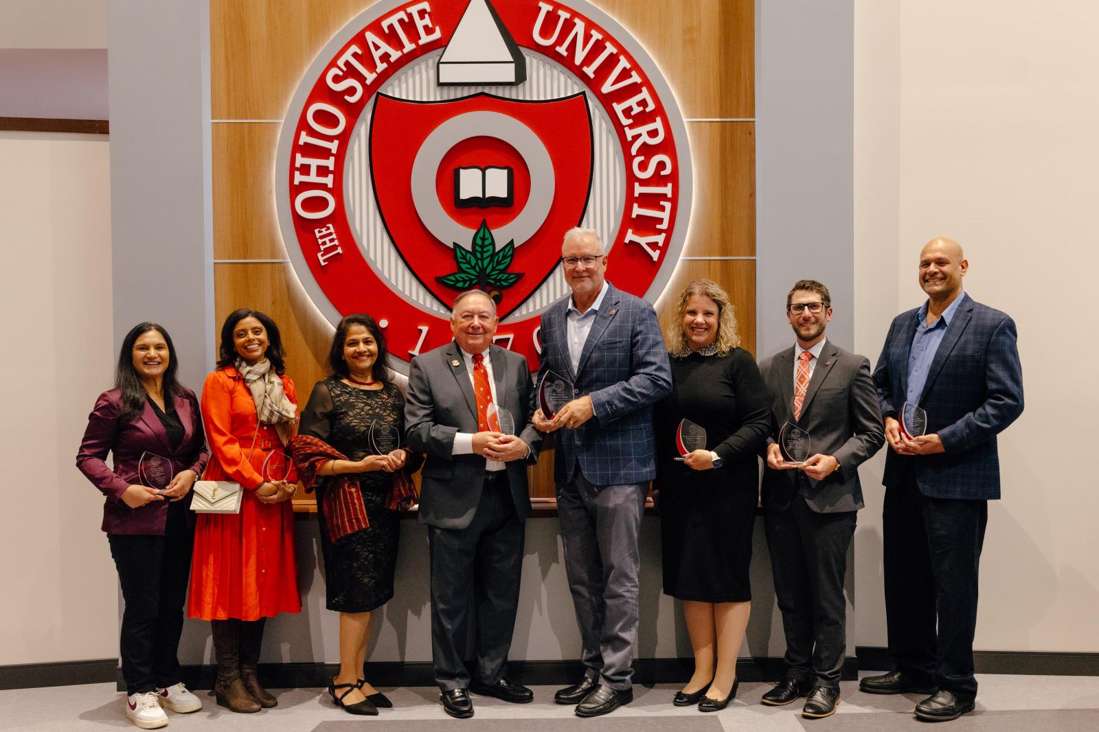 2025 Alumni Awards winners posing as a group in front of The Ohio State University seal