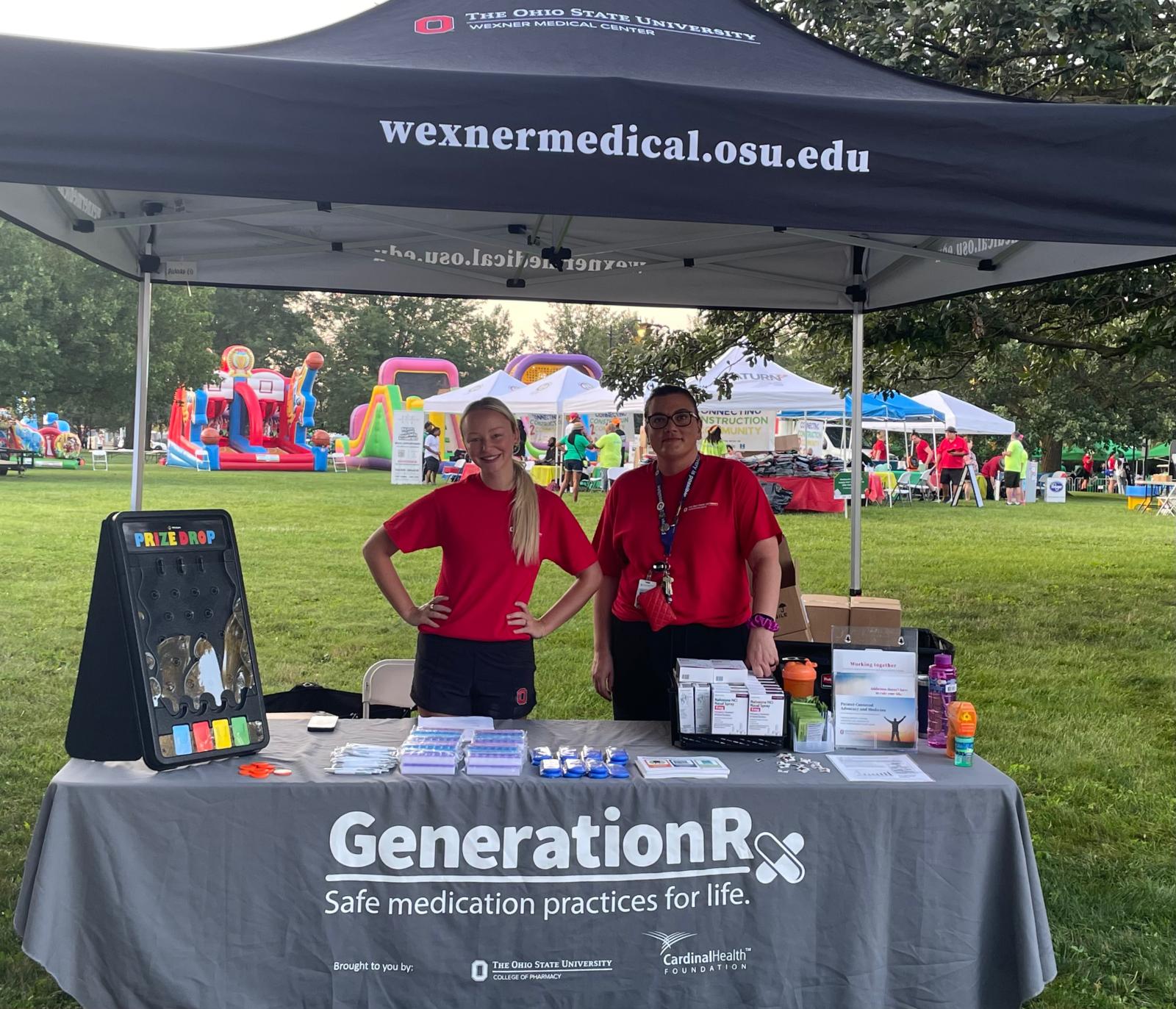 two people in red shirts at a booth at an outdoor event