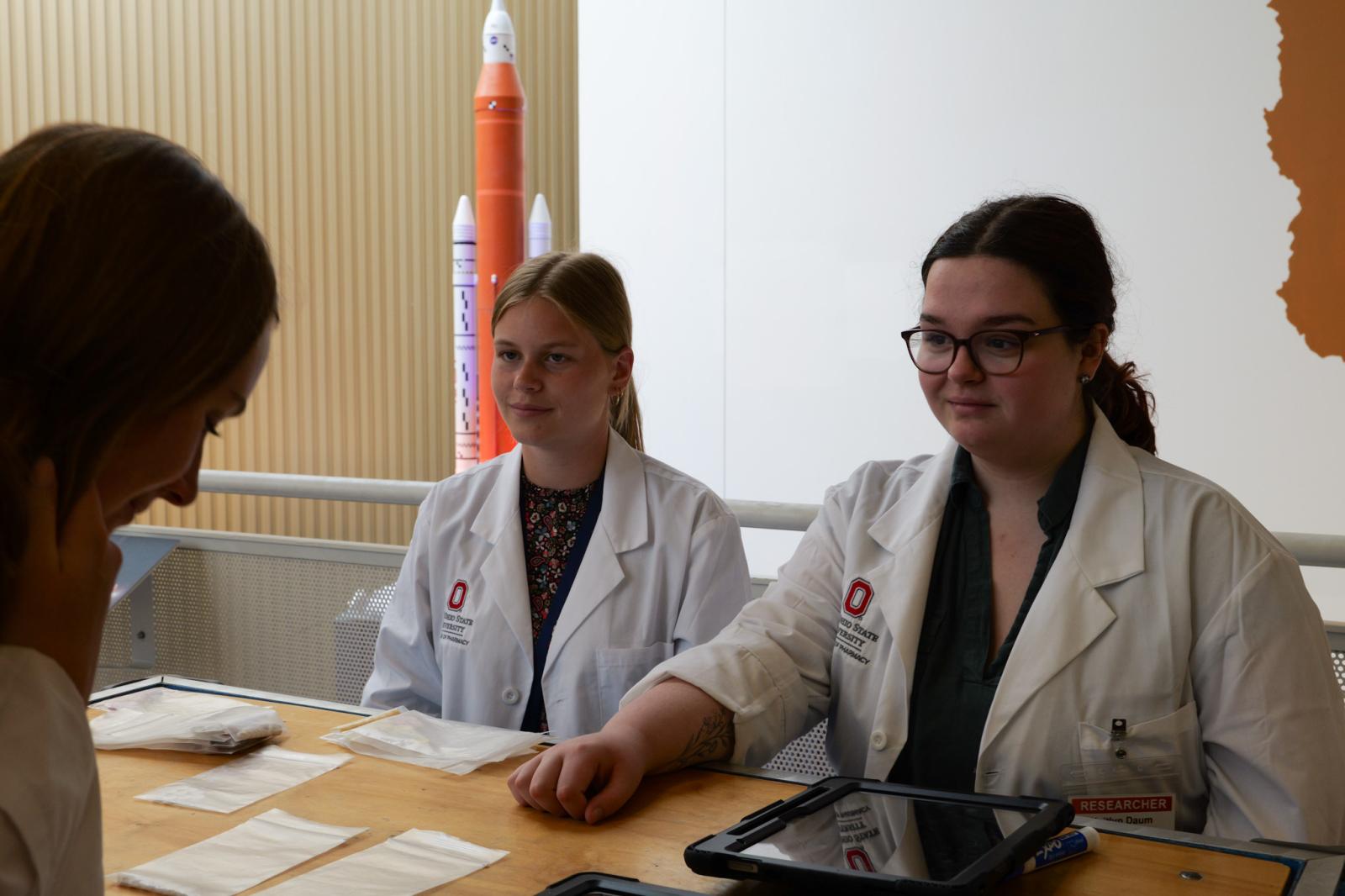 two students speaking with a guest