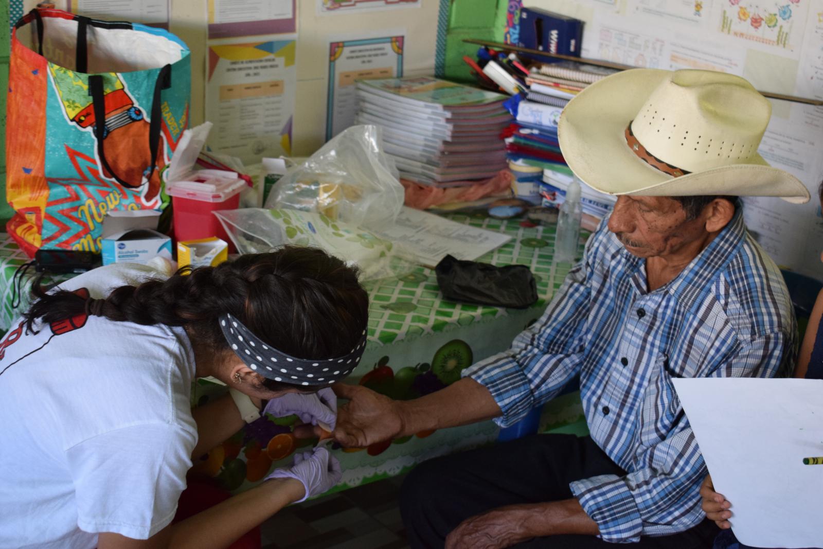 A woman pricking a man's finger.
