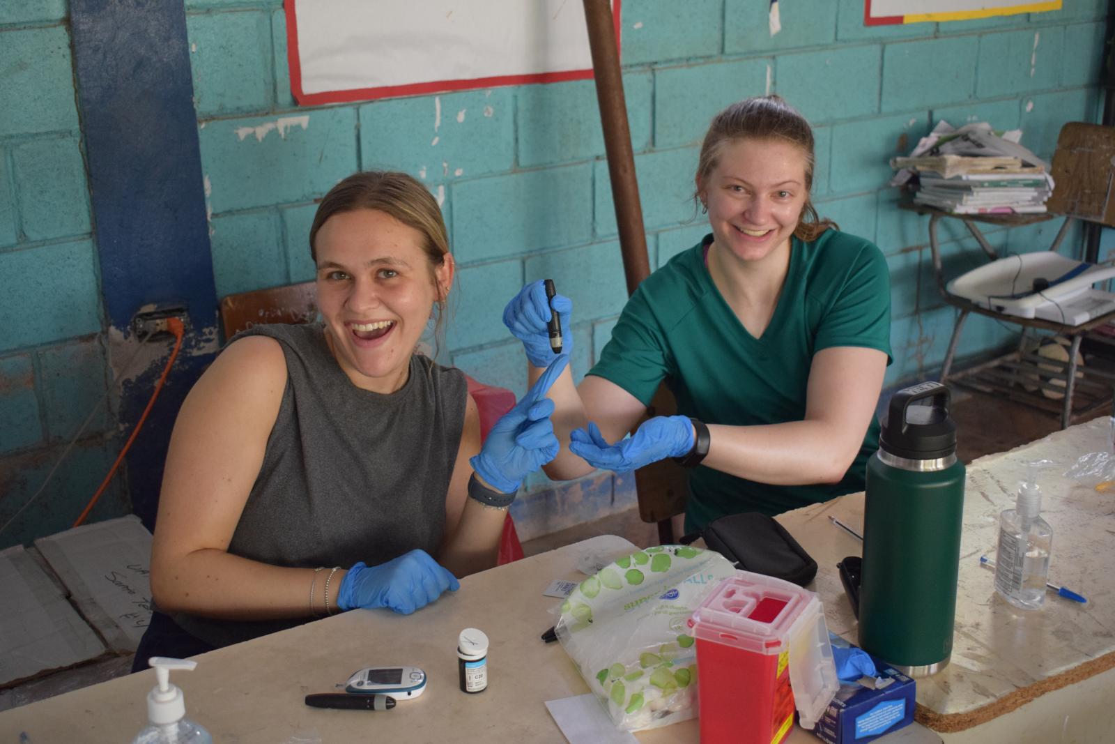 Two students posing with medical devices.