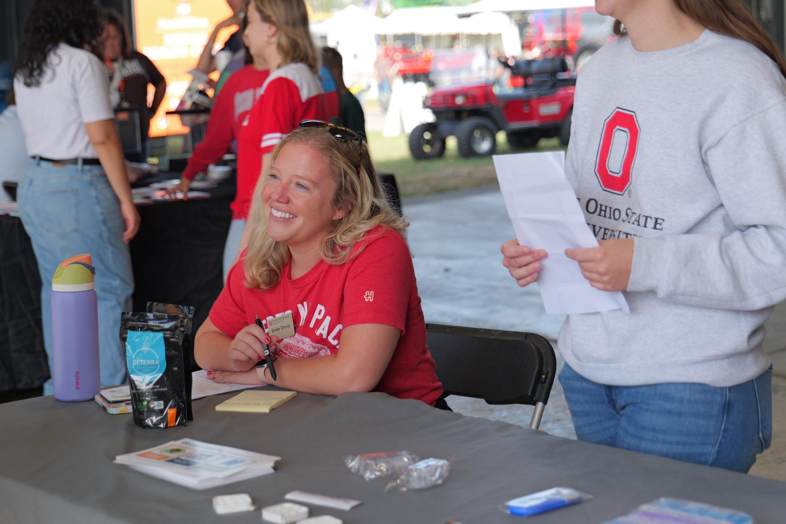 Emilee Drerup speaking with visitors at the Generation Rx table