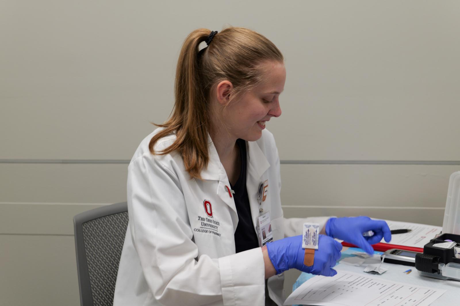 Kaitlynn McDevitt administering a blood glucose test