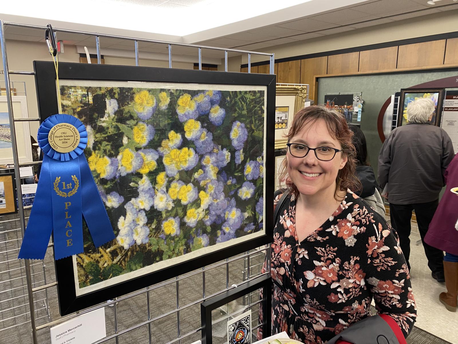 jessica mercerhill posing beside her artwork with 1st place ribbon