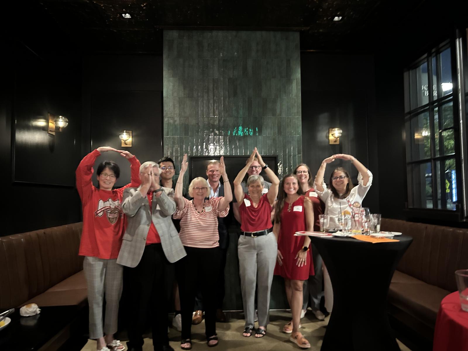 Alumni making an "O" for Ohio State with their arms