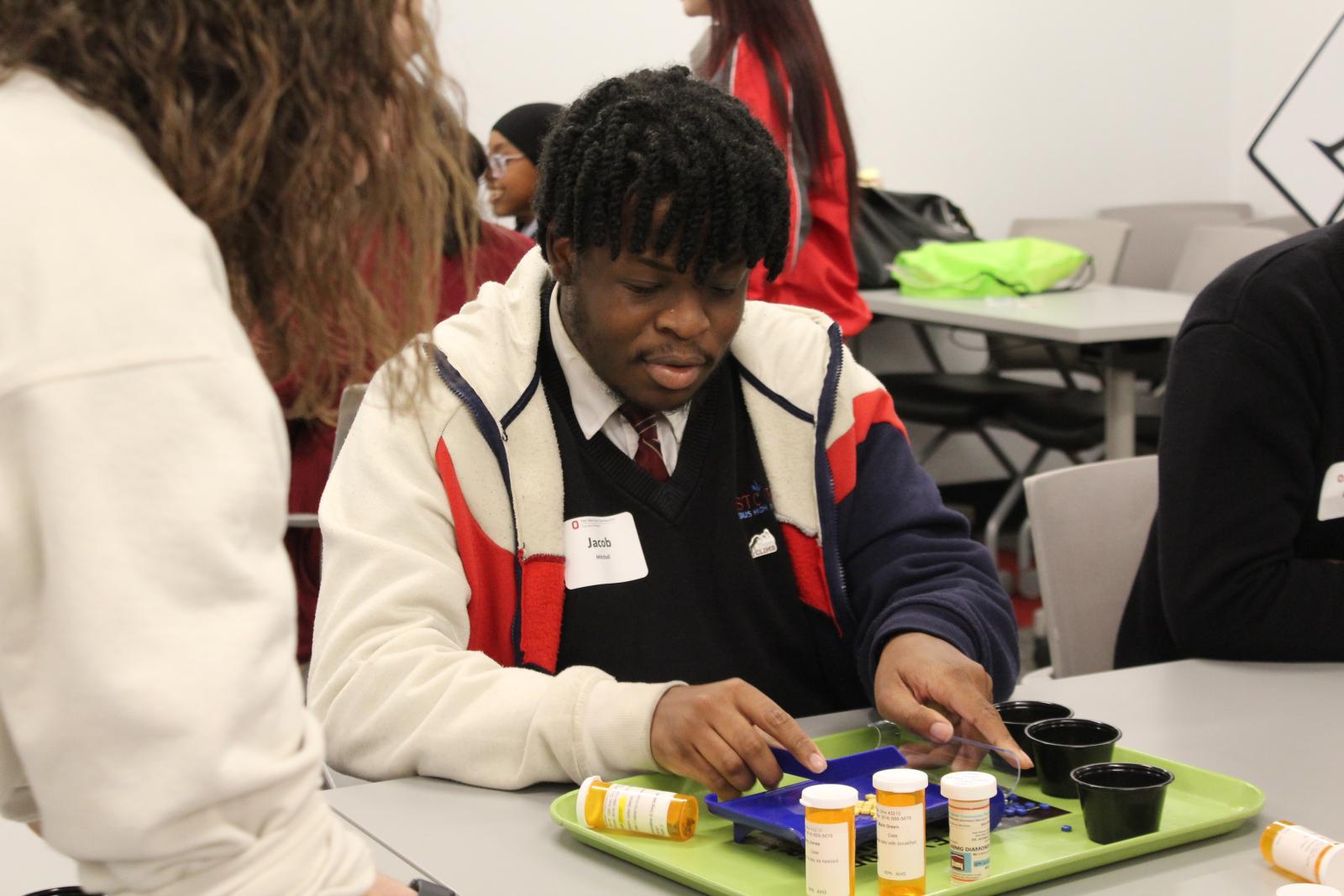 Man simulating medication counting with beads. 