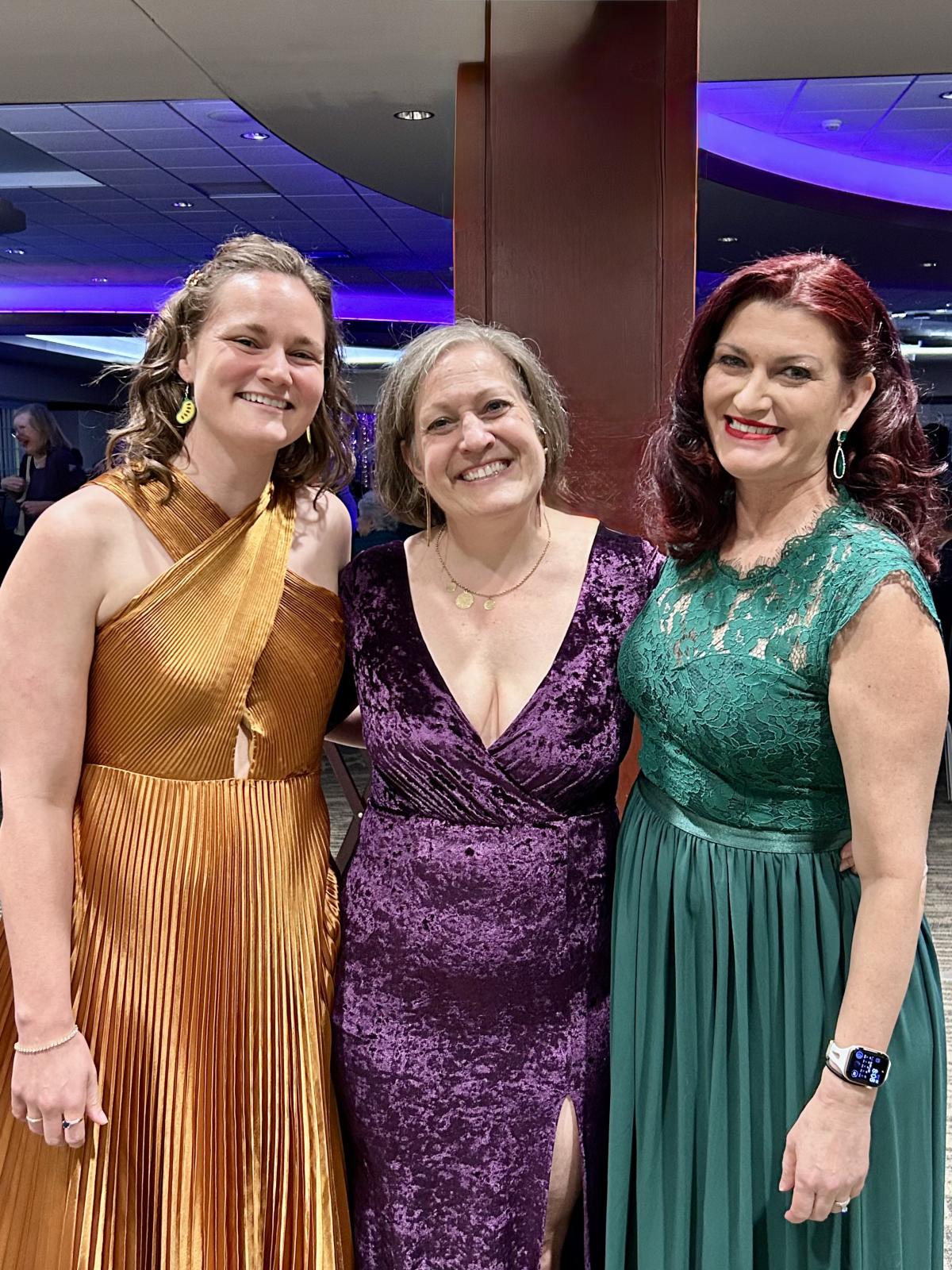 Three people at the gala in dresses