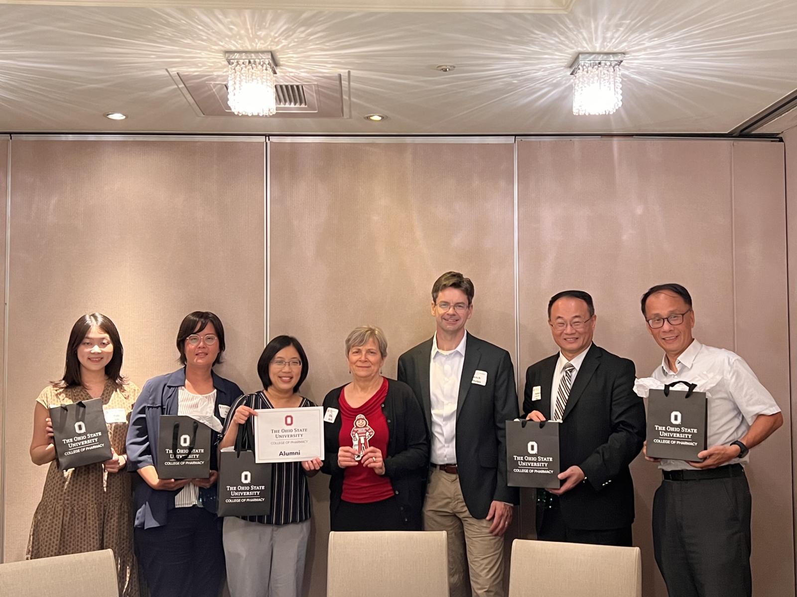 seven people posing holding gifts