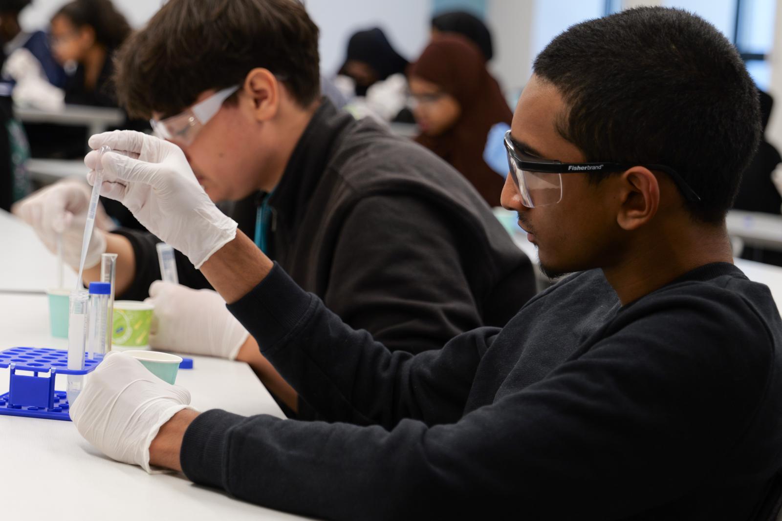 Student inspecting the contents of a vial