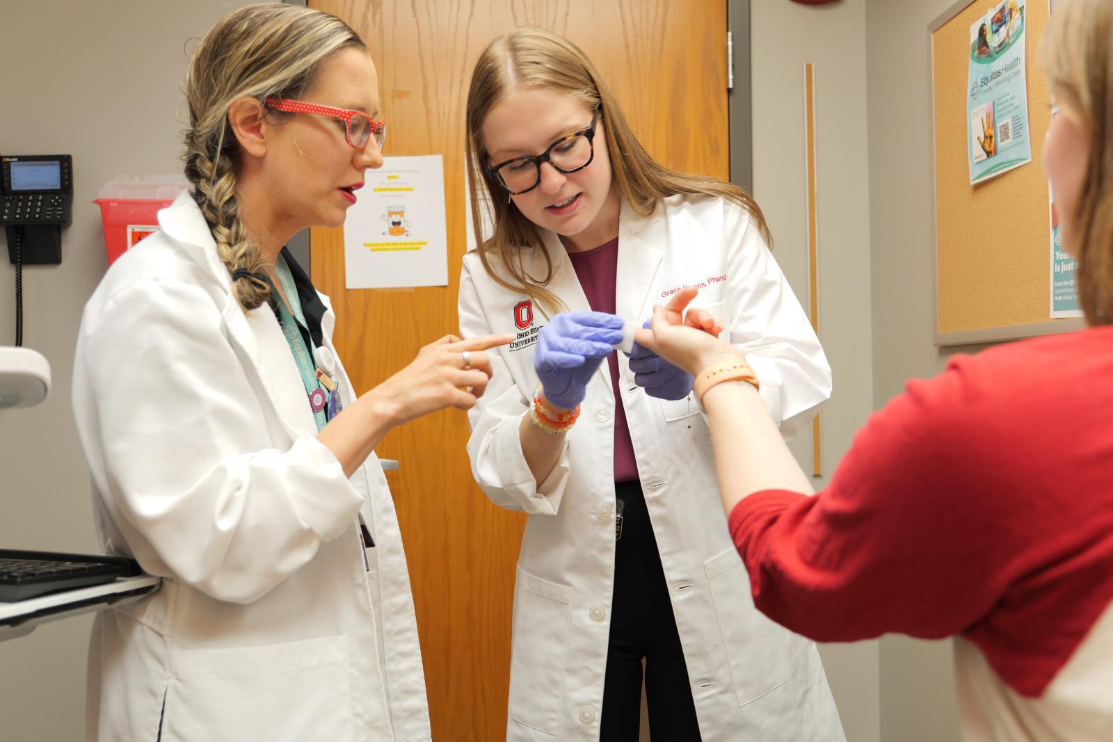 Preceptor showing resident how to perform finger stick