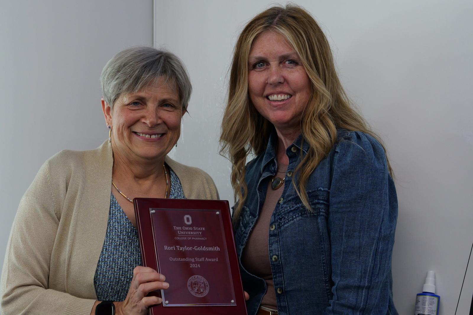 Dean kroetz and Rori posing with plaque