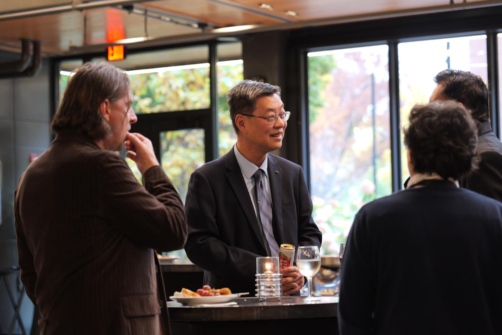 Dr. Lee talking to a group of colleagues. 