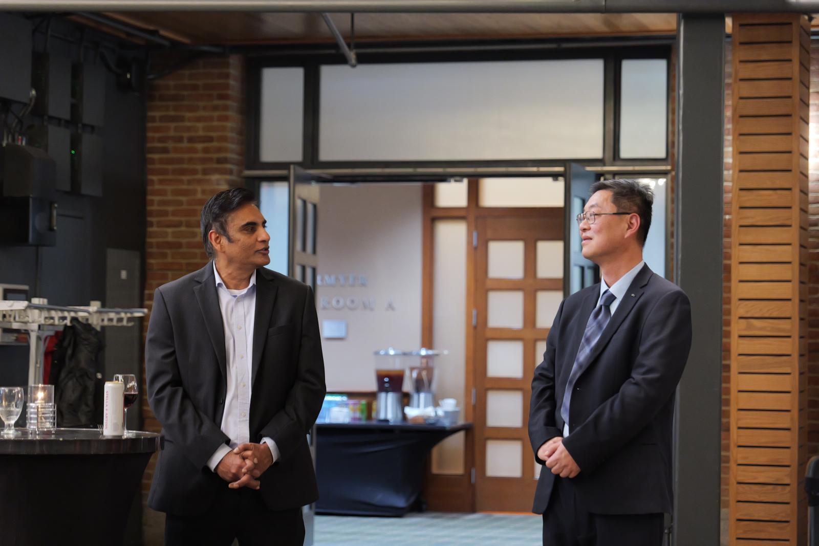 Dr. Lee listening to a colleague give him a closing speech. 