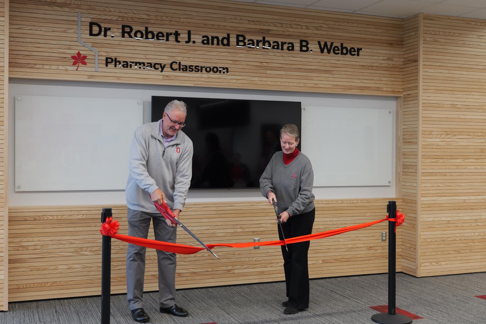 Dr. Weber and Mrs. Weber cutting the ribbon 