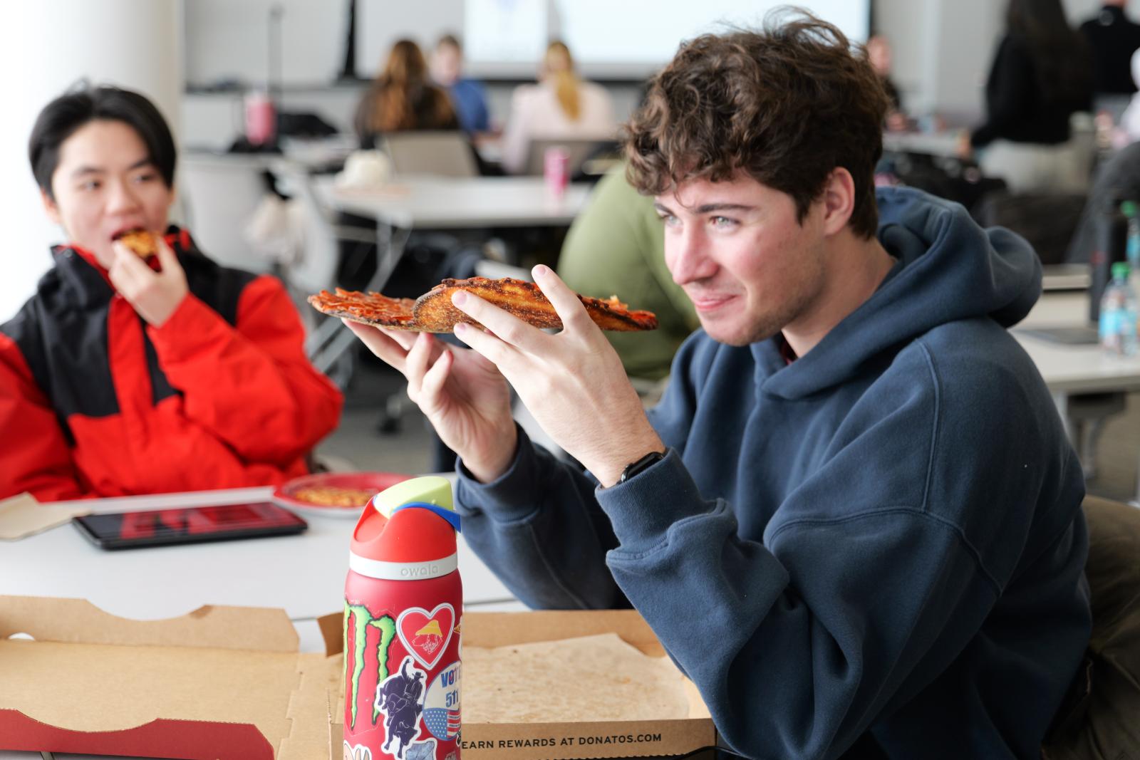 student eating pizza