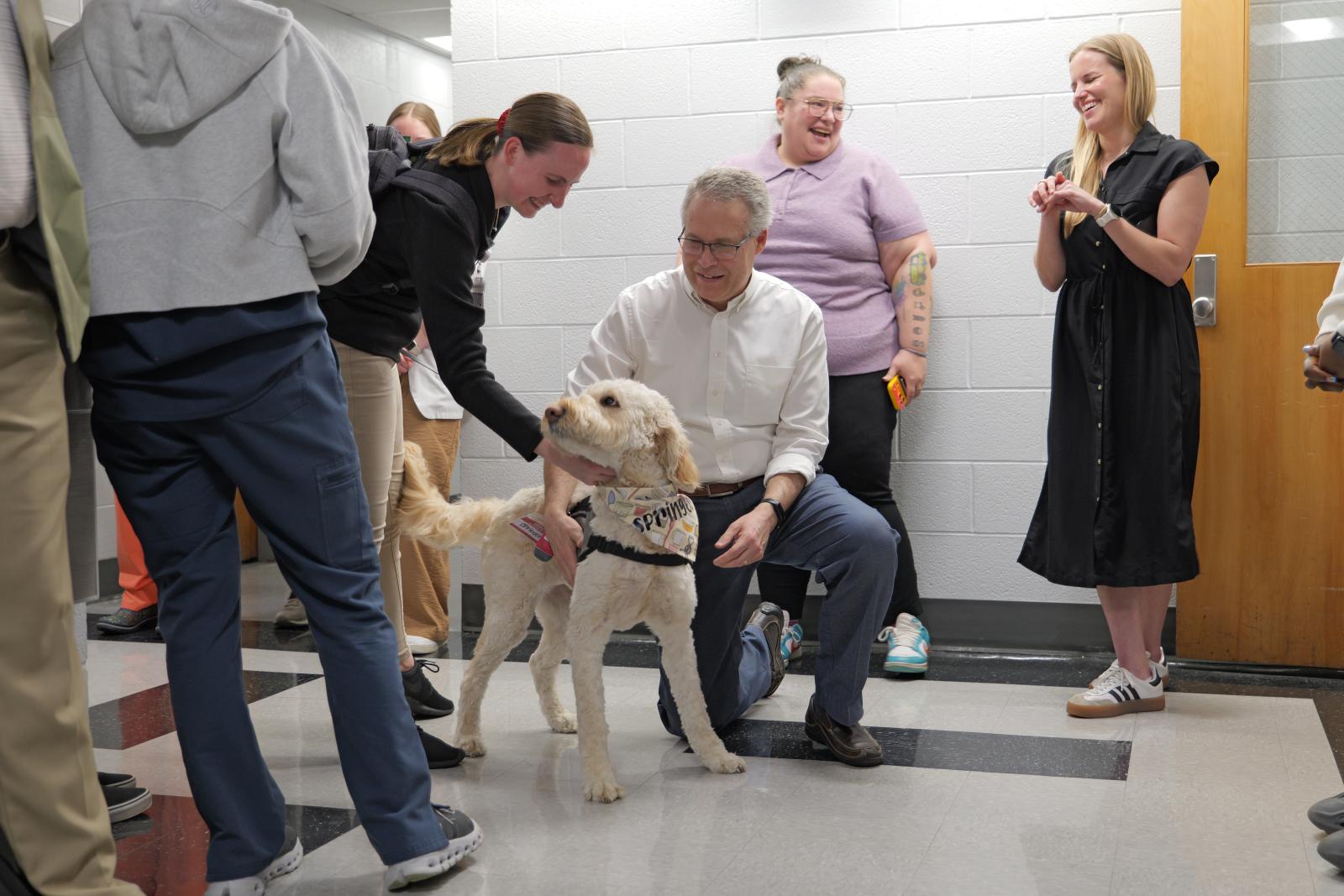 Dr. McAuley petting Springer the golden doodle.