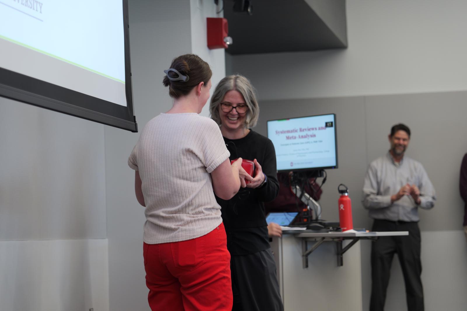 Dr. Kwiek handing Dr. Cline her cookies