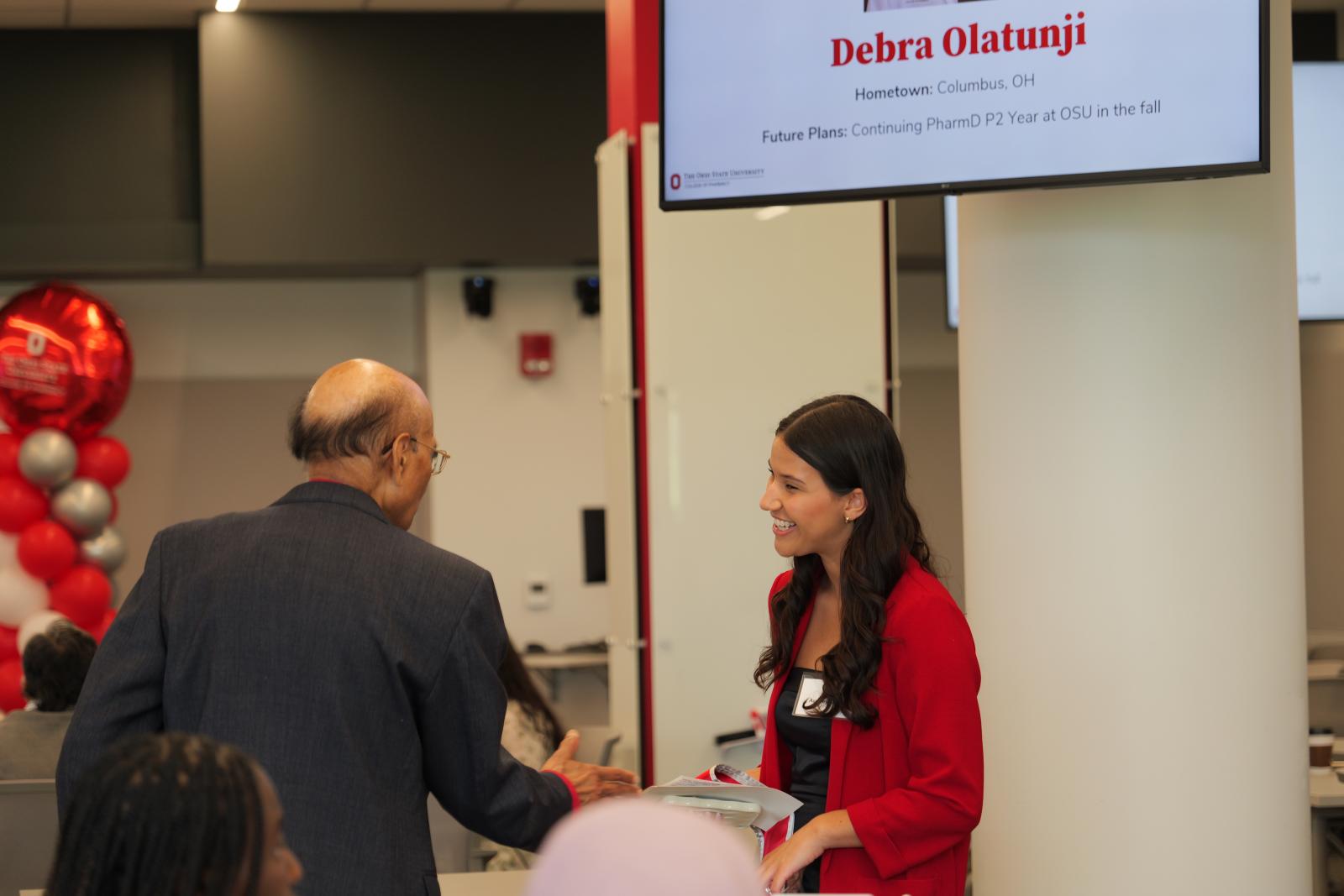 A student smiling talking to Dr. Nahata