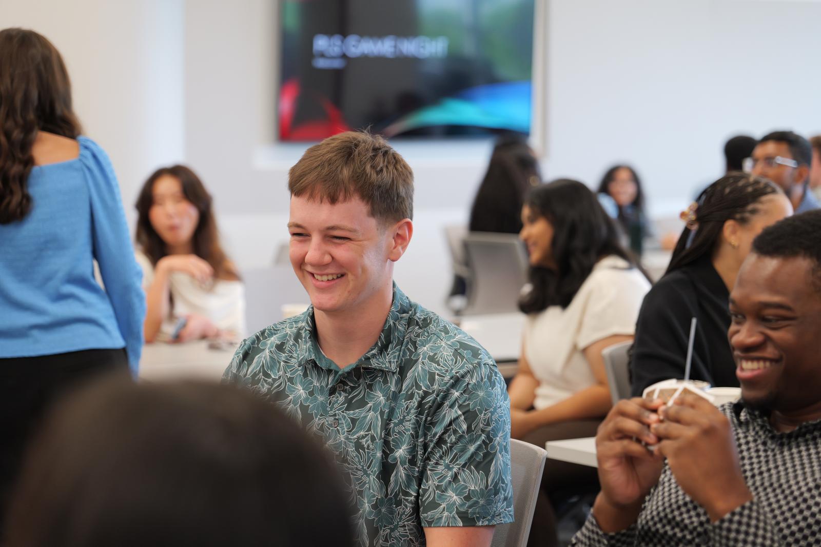 Two students smiling. One is holding cards.