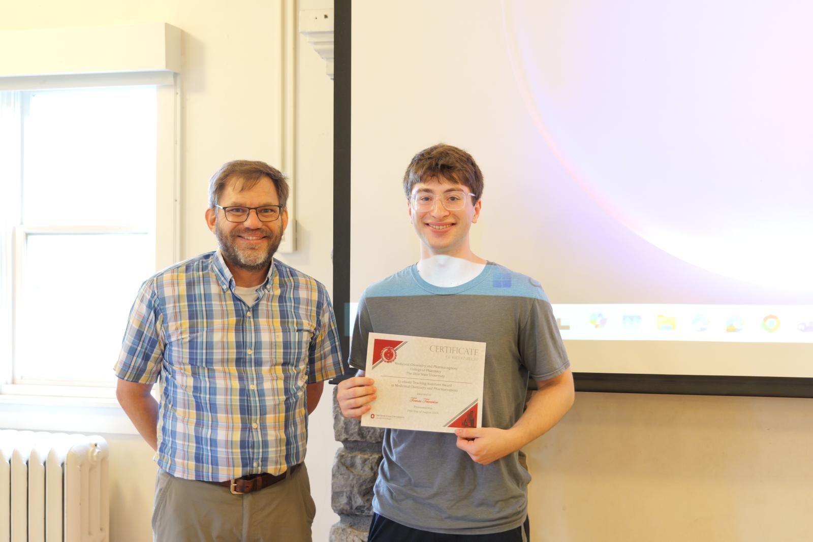 Tomas holding his award